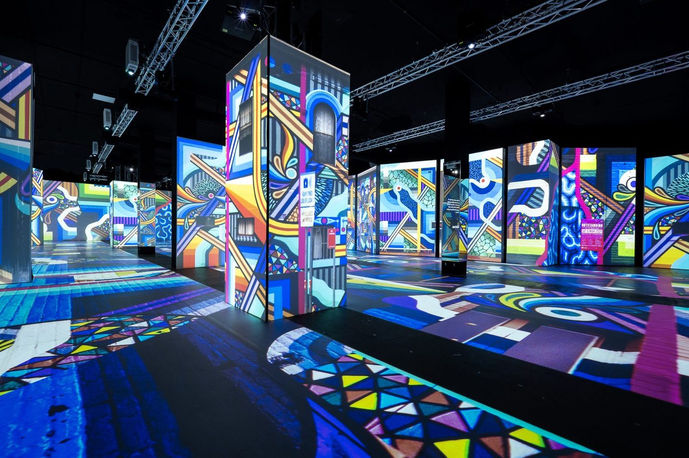 Projection-mapped pillars across the exhibition floor at Magic Box Event Campus