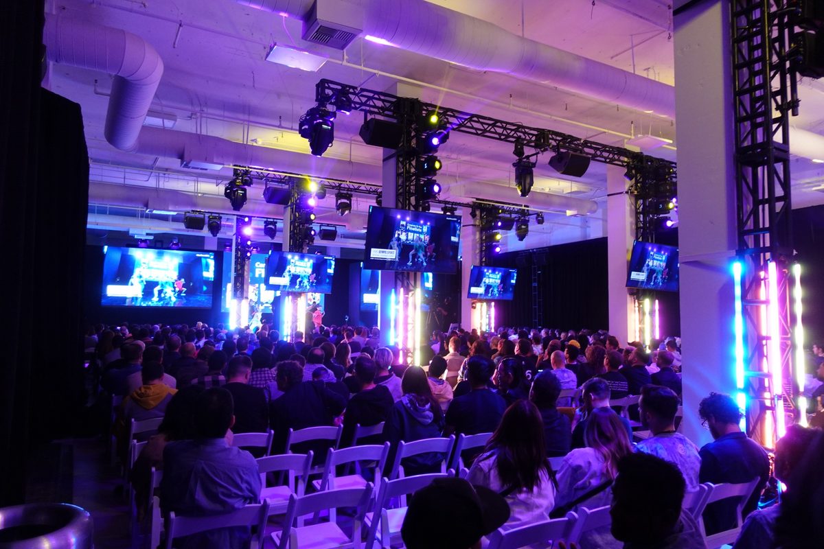 A seated audience facing a lit stage at Magic Box Event Campus